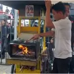 a group of people standing around a small yellow cart with a fire