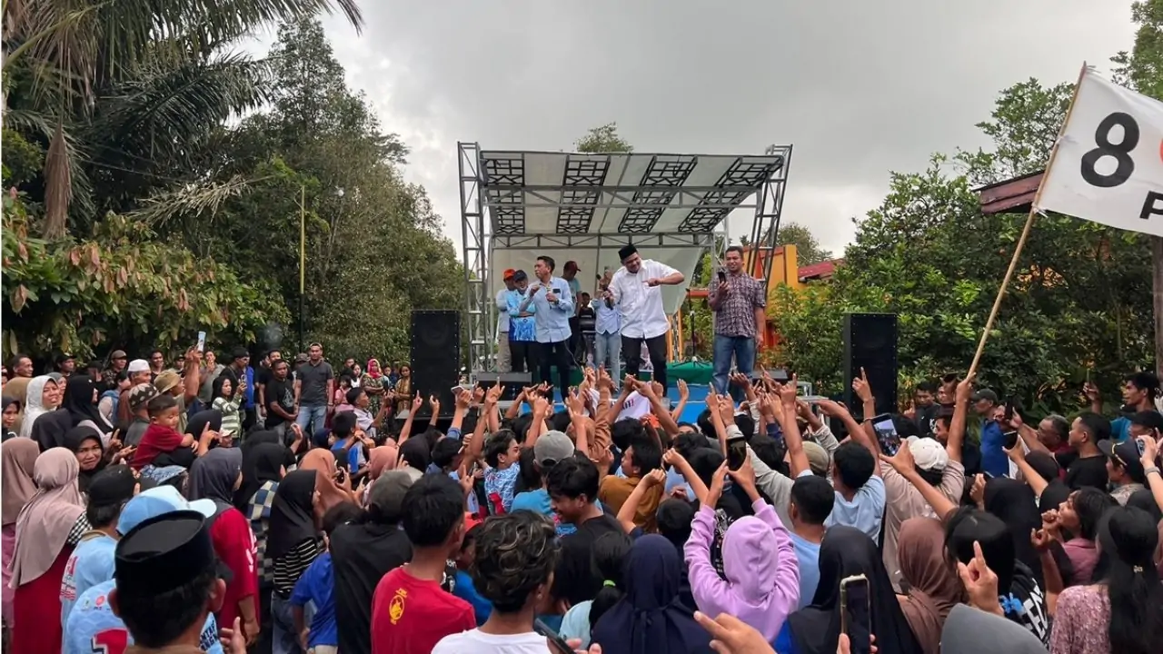 a group of people on a stage with a crowd of people raising their hands