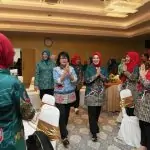 a group of women clapping in a room