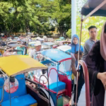 [Foto] Ketua TP PKK Bantaeng Gunya Paramasakhaputri mendampingi Bupati Bantaeng Uji Nurdin bagi-bagi bingkisan lebaran ke tubek dan tukang sapu jalan, Jum'at (28/3).(Dok.IST)